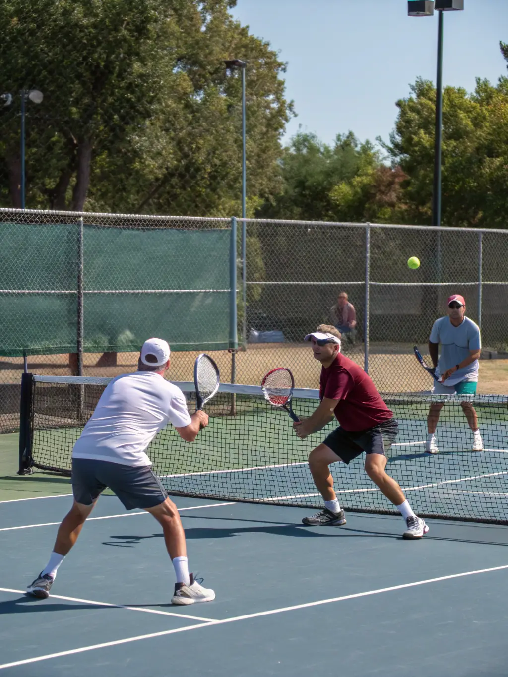 A group of adult tennis players participating in a recreational doubles match at TCV, highlighting the club's emphasis on community engagement.